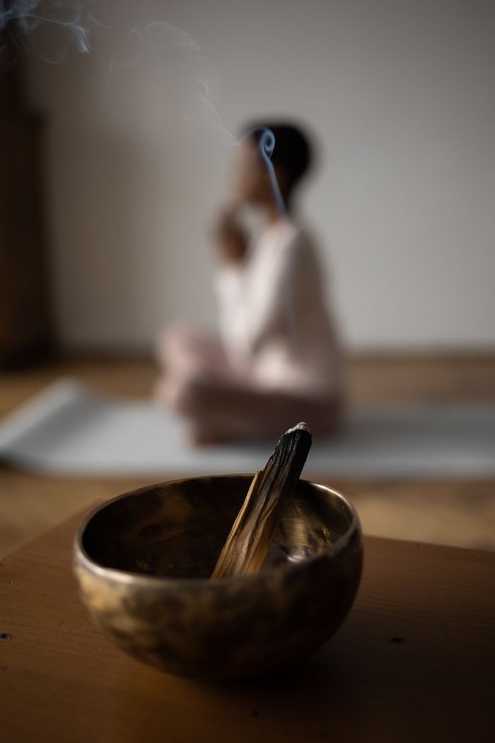 services-01 A serene moment of mindfulness featuring incense in a singing bowl during yoga practice.